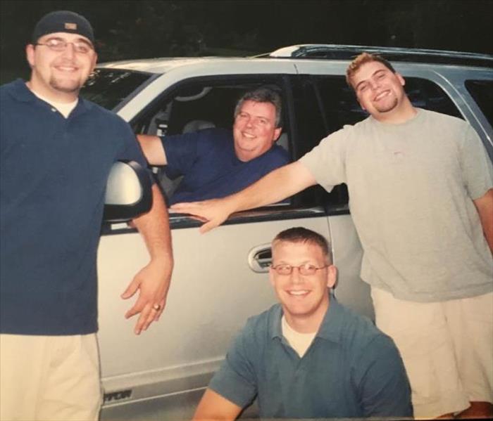 Old family photo containing 4 guys in front of a car.