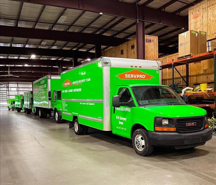 5 Green SERVPRO trucks in a warehouse in Buford, GA waiting to be dispatched to a water restoration project.